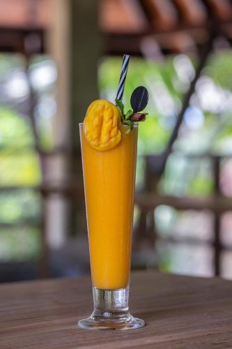 a glass of orange juice with a fruit in it at Ayana Sea in Wadduwa