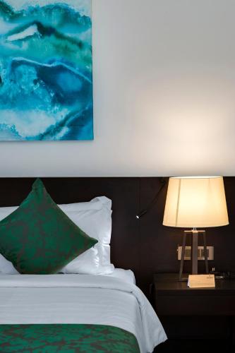 a bedroom with a bed and a table with a lamp at Ayana Sea in Wadduwa