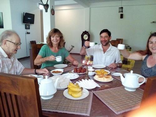 a group of people sitting around a table eating breakfast at Ging View Villa in Galle