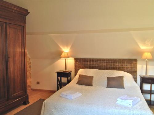 a bedroom with a bed with two pillows on it at Maison Milou in Beynac-et-Cazenac