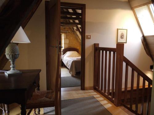 um quarto com um quarto com uma cama e uma escada em Maison Milou em Beynac-et-Cazenac