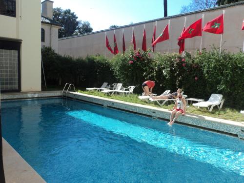 une femme sautant dans une piscine dans l'établissement Hotel Batha, à Fès