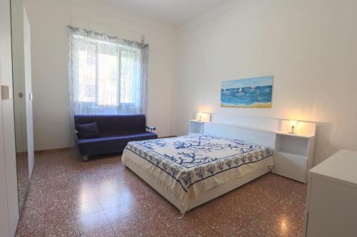 ein Schlafzimmer mit einem Bett und einem blauen Stuhl in der Unterkunft Villetta Angela in Torre San Giovanni Ugento