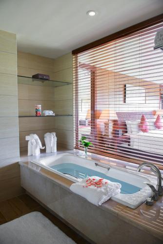 a bathroom with a bath tub with a window at Howard Johnson Conference Resort Chengdu in Dujiangyan