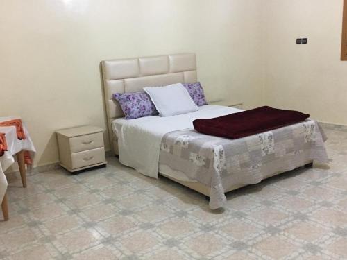 a bedroom with a bed and a night stand at Oasispalmares in Er Rachidia