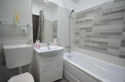 La salle de bains est pourvue d'un lavabo, de toilettes et d'une baignoire. dans l'établissement Rya Home 1, à Bucarest