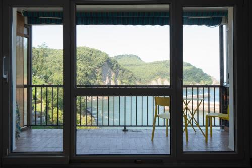 een raam met uitzicht op een balkon bij Armintza Port by Aston Rentals in Arminza