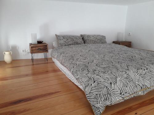 um quarto com uma cama e piso em madeira em La Tia Vinagre em Vejer de la Frontera