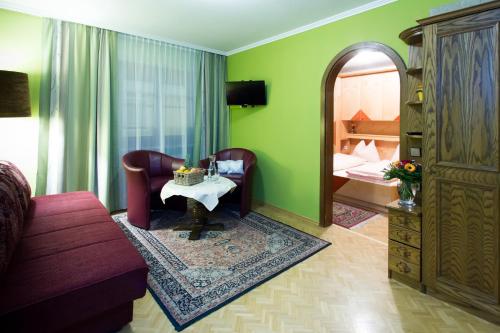 ein Wohnzimmer mit einem Sofa und einem Spiegel in der Unterkunft Hotel Gasthof Brüggler in Radstadt