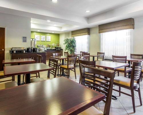 a restaurant with tables and chairs and a kitchen at Sleep Inn Columbia in Columbia
