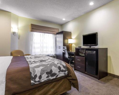 a hotel room with a bed and a flat screen tv at Sleep Inn Columbia in Columbia