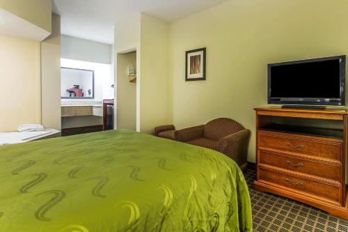 a hotel room with a bed and a flat screen tv at Quality Inn & Suites Orangeburg in Orangeburg