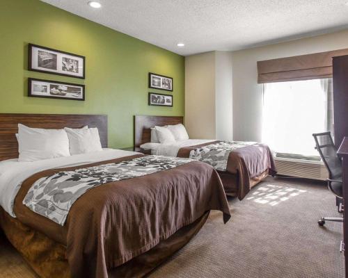 a hotel room with two beds and a window at Sleep Inn Columbia in Columbia