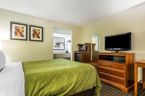 a hotel room with a bed and a flat screen tv at Quality Inn & Suites Orangeburg in Orangeburg