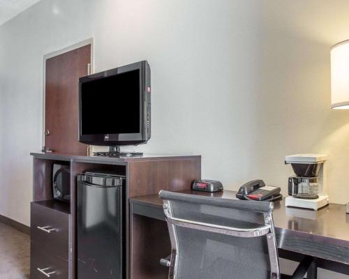 a hotel room with a desk with a tv and a chair at Sleep Inn Columbia in Columbia