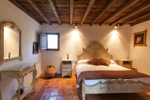 a bedroom with a large bed and a mirror at Agroturismo Can Pere Sord in Sant Joan de Labritja
