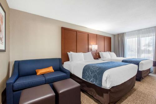 a hotel room with two beds and a blue chair at Comfort Inn & Suites Pinetop Show Low in Pinetop-Lakeside