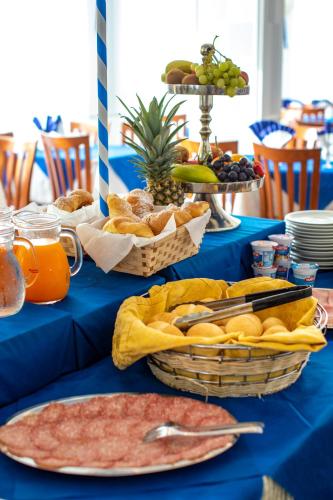 a blue table topped with baskets of bread and fruit at Hotel Holland in Rimini