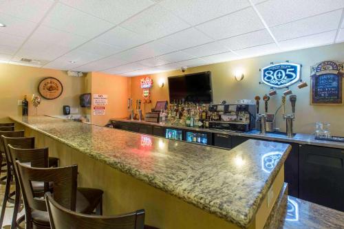 a bar in a restaurant with a counter and chairs at The Oaks Hotel & Suites in Paso Robles