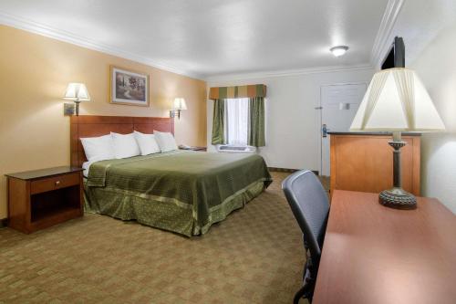 a hotel room with a bed and a desk at Rodeway Inn Adelanto US 395 in Adelanto
