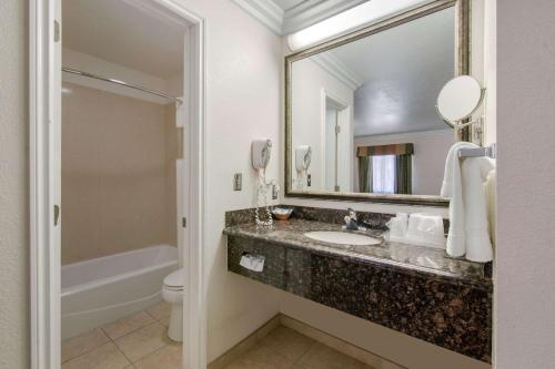 y baño con lavabo, aseo y espejo. en Rodeway Inn Adelanto US 395, en Adelanto