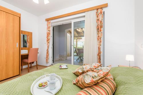 een slaapkamer met een bed met een bord eten erop bij Villas Rab Banjol in Rab