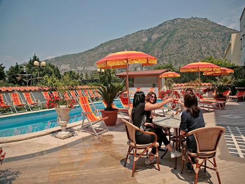 a group of women sitting at a table near a pool at Hotel Albatros in Piano di Sorrento