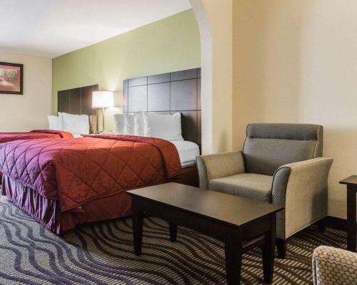 Habitación de hotel con cama y silla en Quality Inn & Suites near Coliseum and Hwy 231 North, en Montgomery