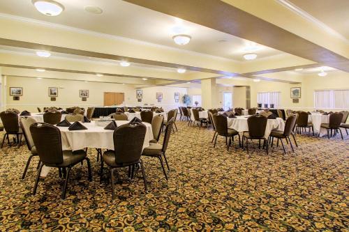 un salón de banquetes con mesas y sillas blancas en Clarion Suites Anchorage Downtown, en Anchorage