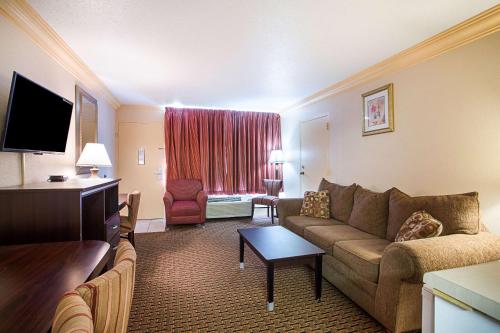 a hotel room with a couch and a living room at Parkway Inn of Birmingham in Birmingham