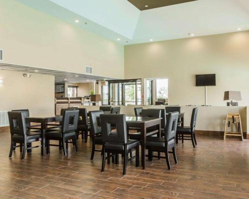 a dining room with black chairs and tables and a television at Quality Inn & Suites North Montgomery in Montgomery