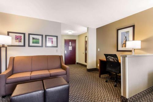 a living room with a couch and a desk at Comfort Suites Tuscaloosa near University in Tuscaloosa