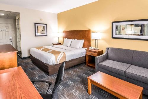 a hotel room with a bed and a couch at Quality Inn Alexander City in Alexander City