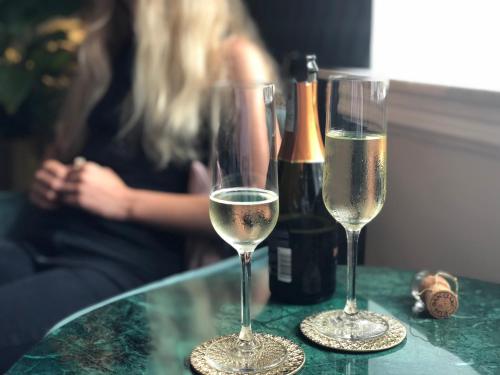 two glasses of champagne and a bottle of wine on a table at Annas Hotell in Kristianstad