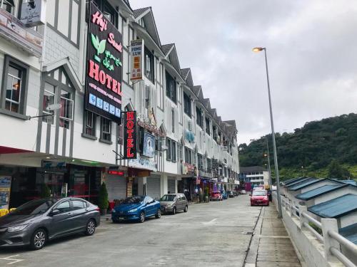 a street with cars parked in front of buildings at Haji Saudi Hotel in Cameron Highlands