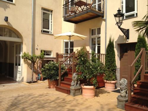 a building with an umbrella and some potted plants at Garden Living - Boutique Hotel in Berlin