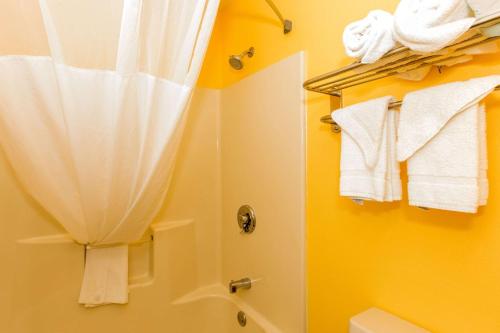 uma casa de banho com um chuveiro e toalhas brancas em Quality Inn Albertville US 431 em Albertville