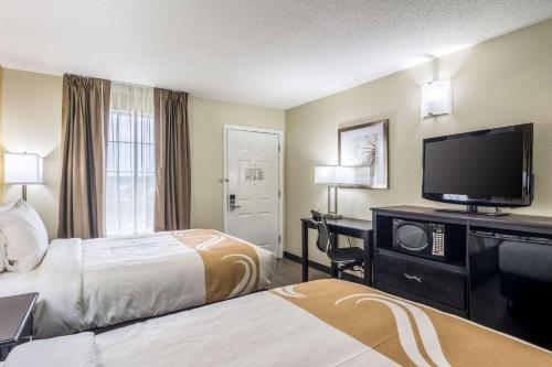 a hotel room with two beds and a flat screen tv at Quality Inn Auburn University Area in Auburn