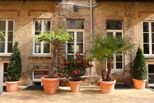 a group of potted plants in front of a brick building at Garden Living - Boutique Hotel in Berlin