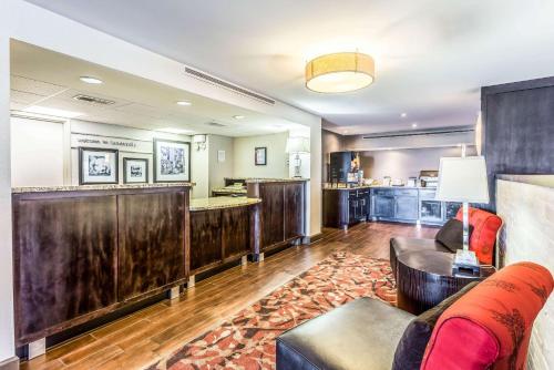 a living room with a couch and a bar at Clarion Pointe Huntsville Research Park in Huntsville