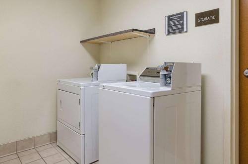 a laundry room with a washer and dryer with a box at Quality Suites Springdale West I-49 in Springdale