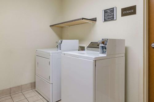 a laundry room with a washer and dryer with a box at Quality Suites in Springdale