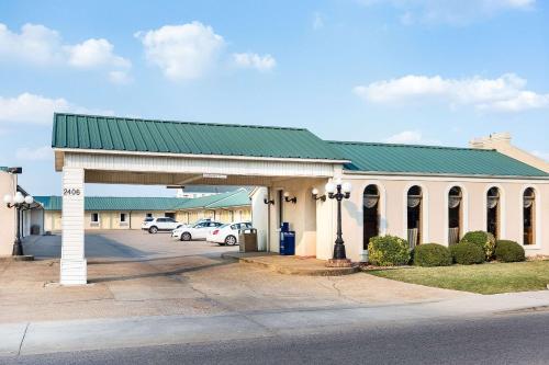 a building with a green roof and a parking lot at Econo Lodge Jonesboro in Jonesboro