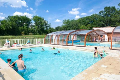 un groupe de personnes dans une piscine dans l'établissement Village Vacances - DéfiPlanet', à Dienné