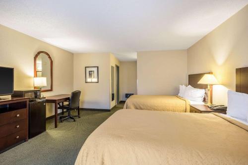 a hotel room with two beds and a desk at Quality Inn & Conference Center in Heber Springs