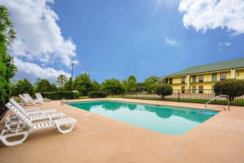 a swimming pool with lounge chairs and a building at Quality Inn & Conference Center in Heber Springs
