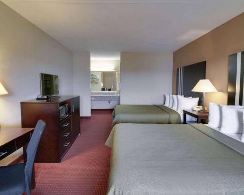 una camera d'albergo con due letti e una televisione di Quality Inn & Suites Clarksville a Clarksville
