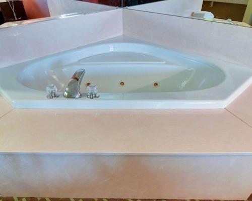 Una bañera blanca con dos figuras. en Quality Inn & Suites Pine Bluff AR, en Pine Bluff
