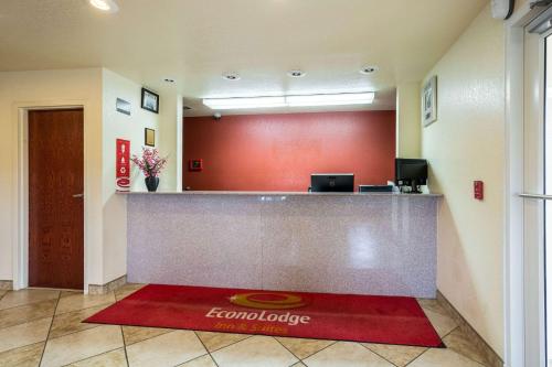 a hotel lobby with a reception desk and a red wall at Econo Lodge Inn & Suites Searcy in Searcy