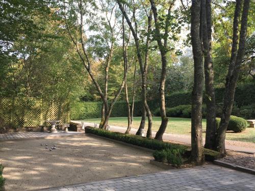 a park with a bench and trees and grass at Les Confidences de Messire Sanglier, stylished guest houses in Beauraing